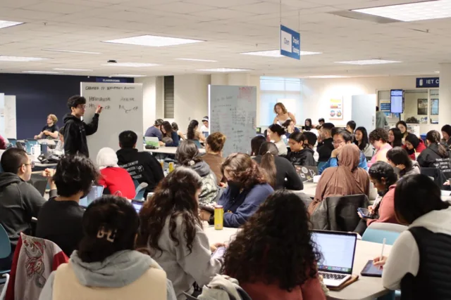 Bryant teaching an Organic Chemistry review session in a full classroom.
